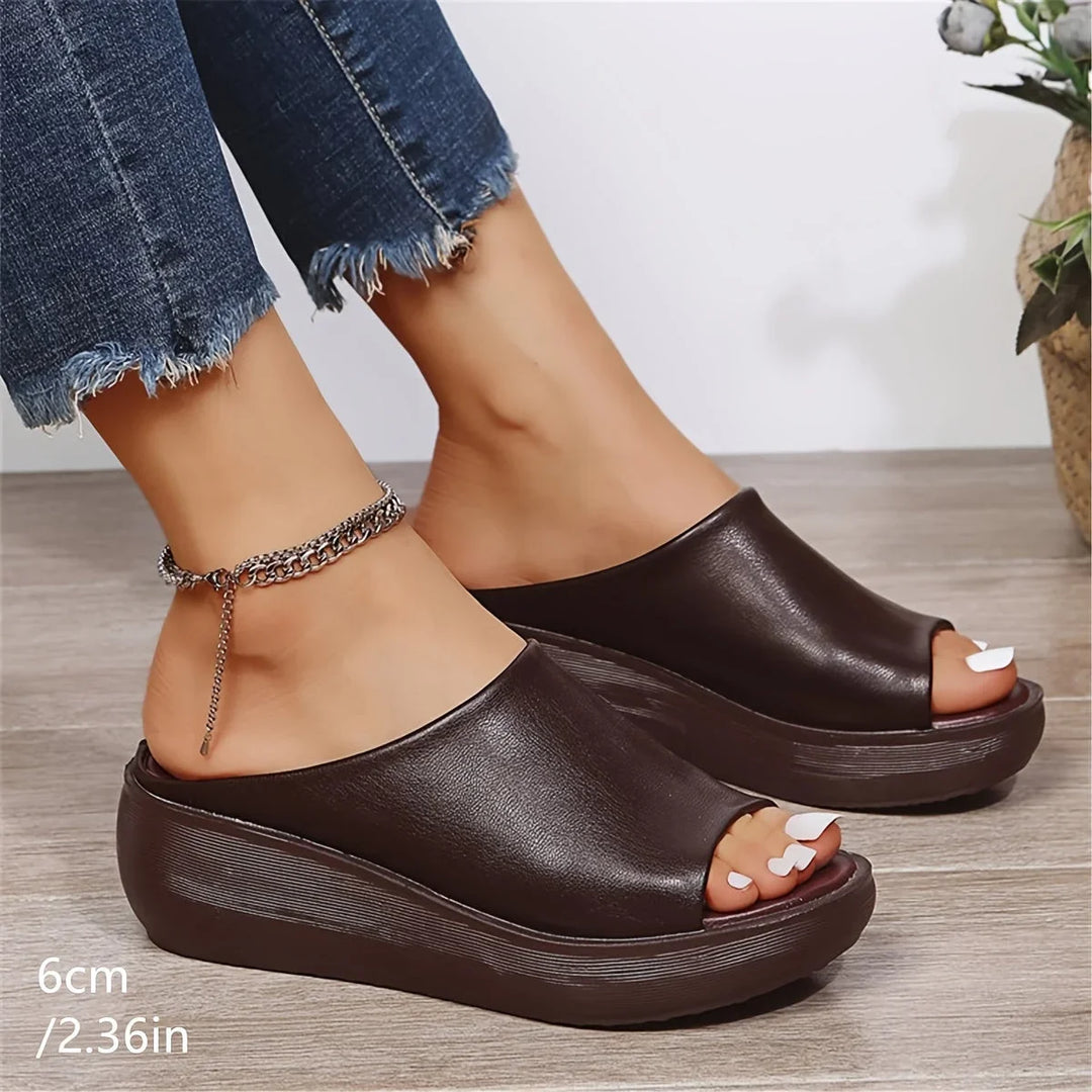 Comfortable brown slip-on sandals for women, featuring a supportive wedge heel and stylish open-toe design.