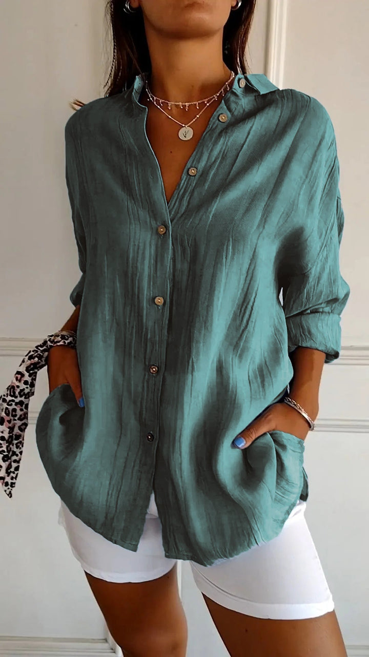 Classic women's button-down blouse with long sleeves, ideal for both casual and professional settings.