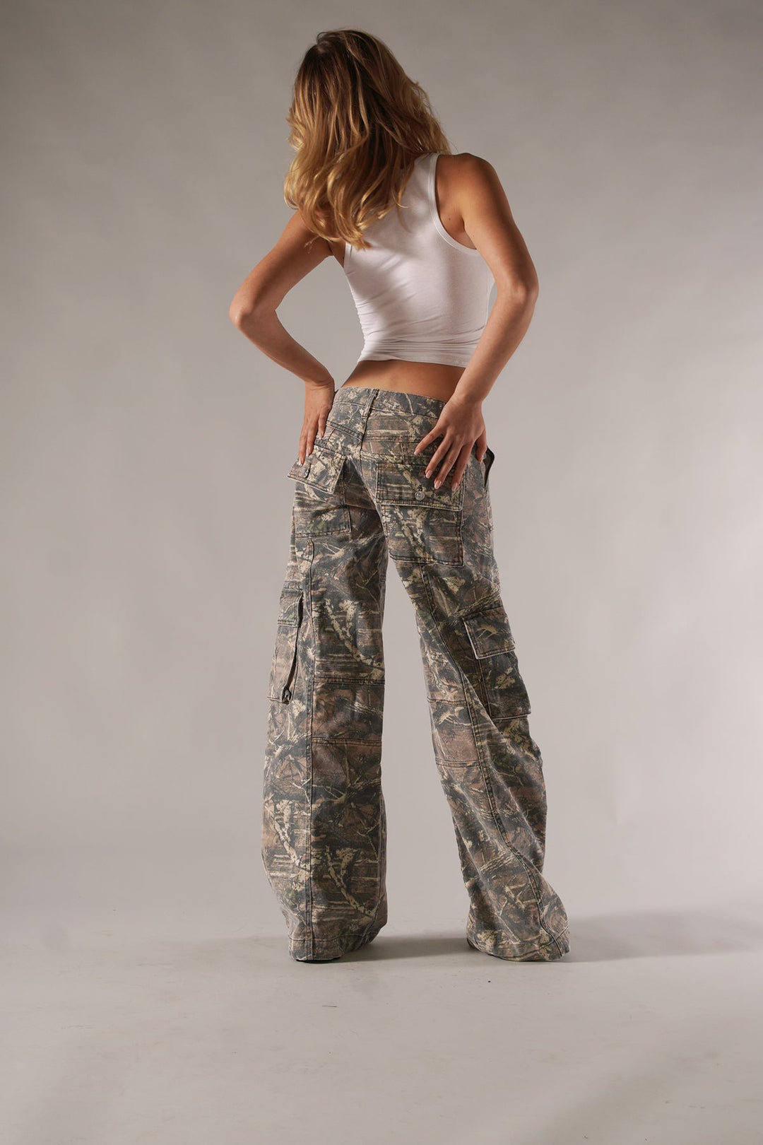 Fashionable women's camouflage cargo trousers. Streetwear utility pants with practical pockets and a comfortable wide leg.