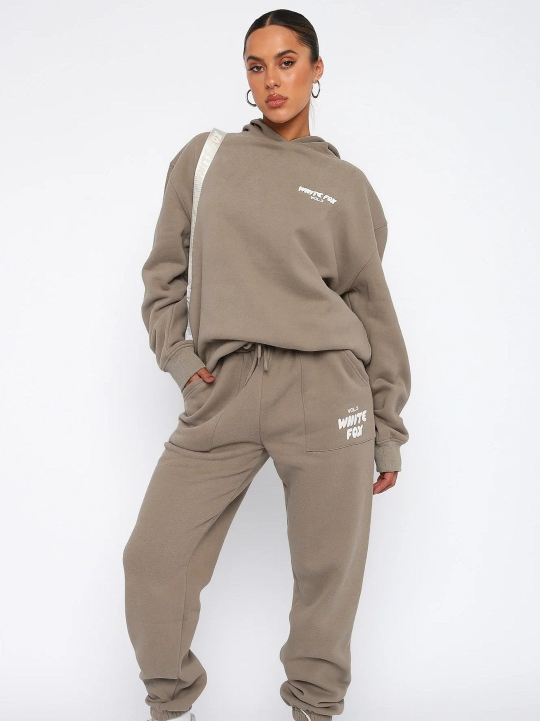 Women's fashionable cropped tracksuit featuring a hoodie & joggers, designed for comfort & active look with back print.