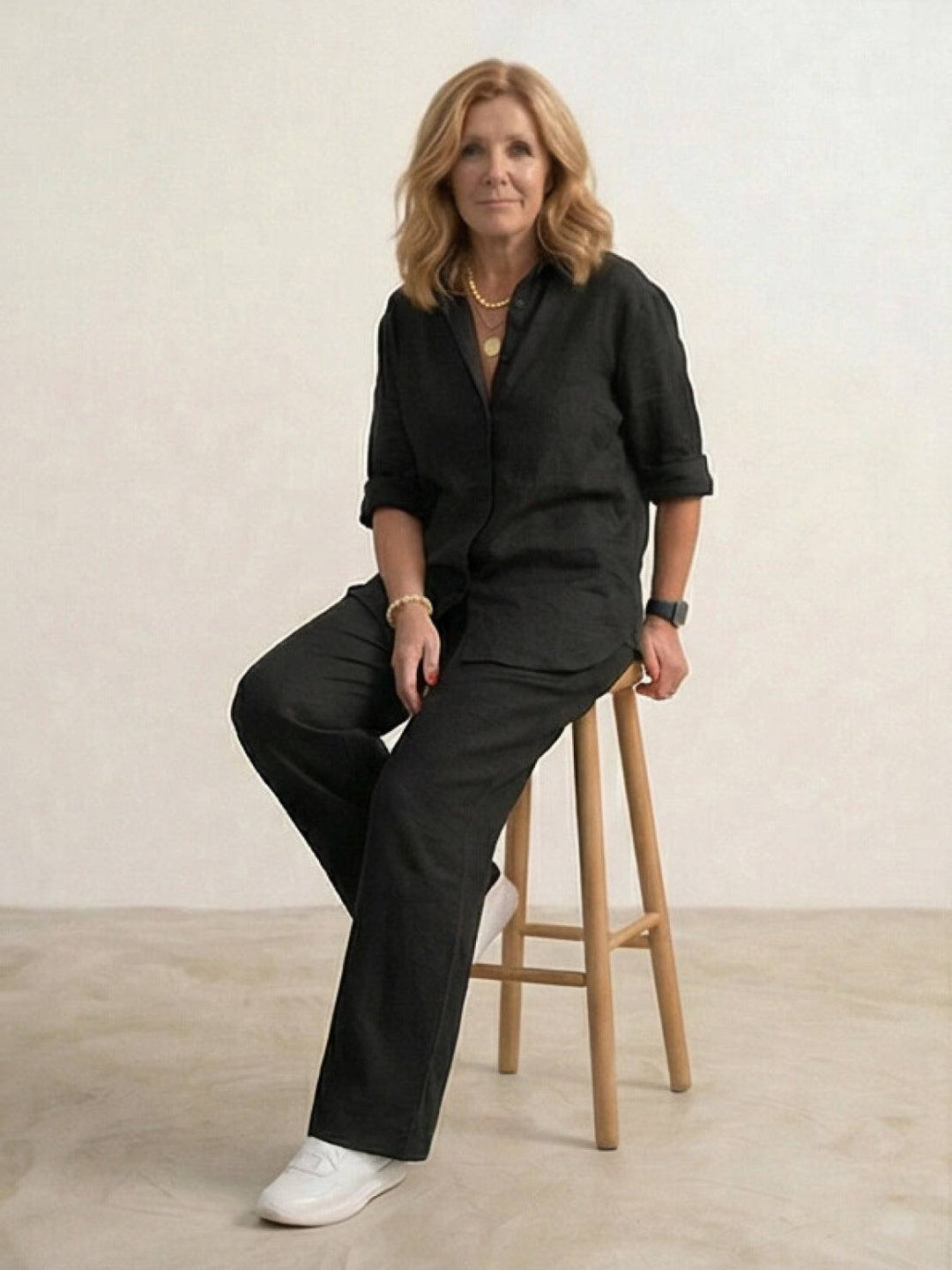 Woman walking, wearing a chic two-piece button-down shirt & wide-leg pants set.