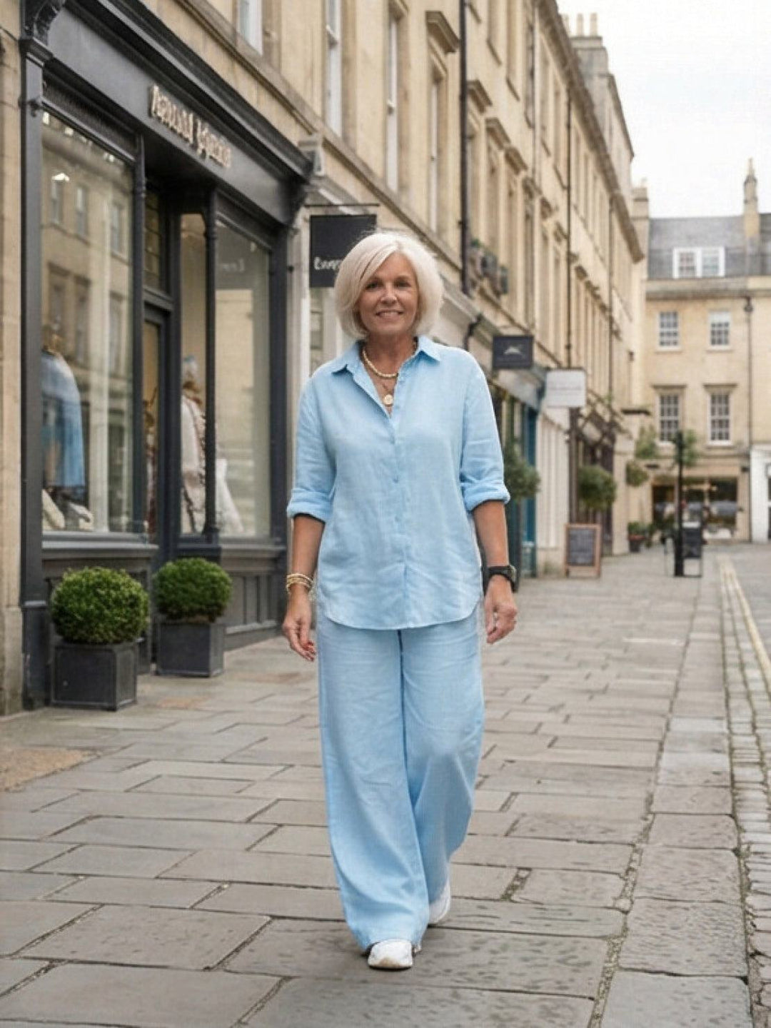 Back view of women's elegant two-piece lounge wear: button-down shirt & wide-leg pants.