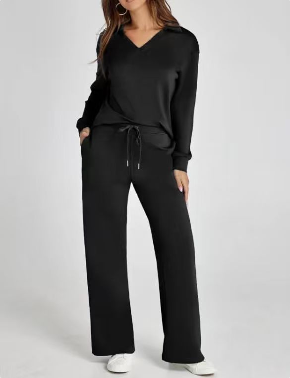 Model showcasing women's casual two-piece zip-neck top & wide-leg pants set. Modern, comfy, and stylish.