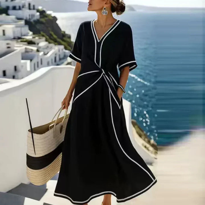 Comfortable women's V-neck midi dress, relaxed fit, featuring elegant piping and useful pockets for everyday style.