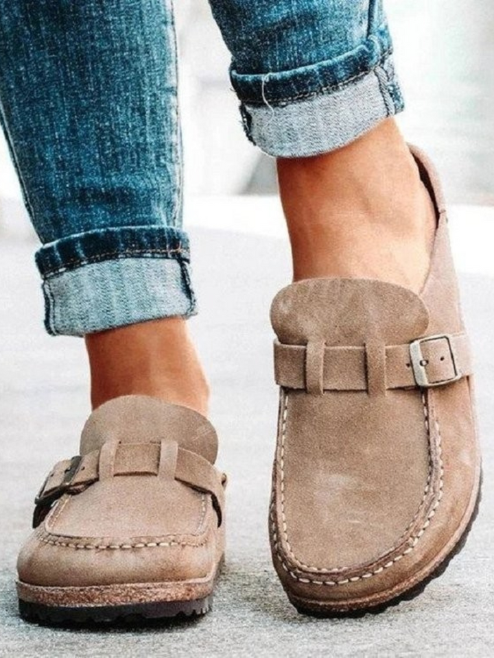 Woman wearing Charlotte buckle clogs, showcasing comfortable & supportive everyday slip-on footwear.