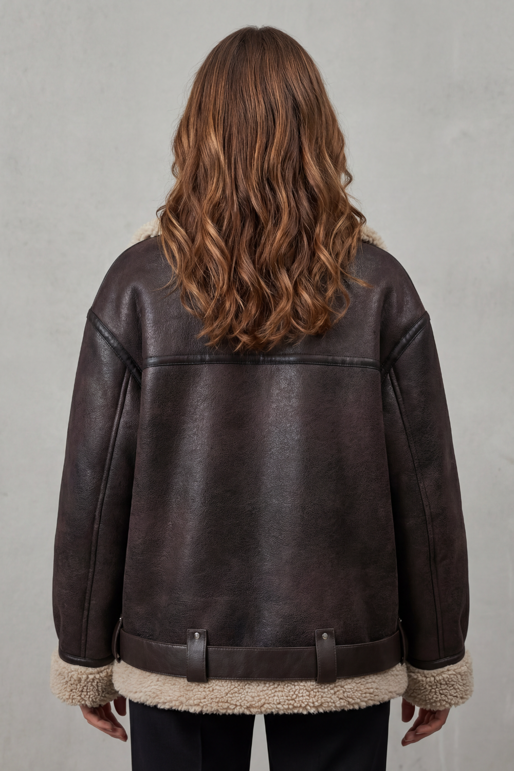Close-up of the adjustable belt and chic details on a women's warm aviator winter jacket.