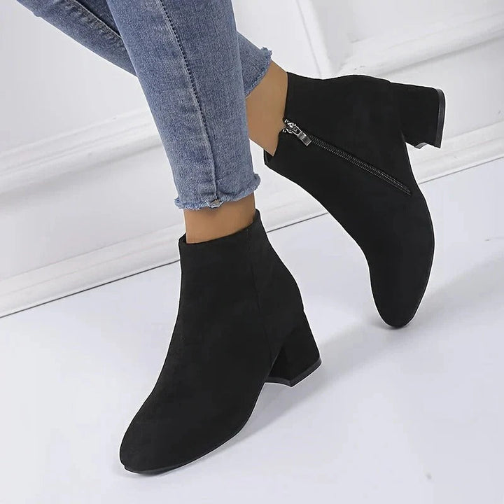 Elegant ladies' block heel ankle boots feature a convenient side zip, ideal for chic fall/winter outfits.