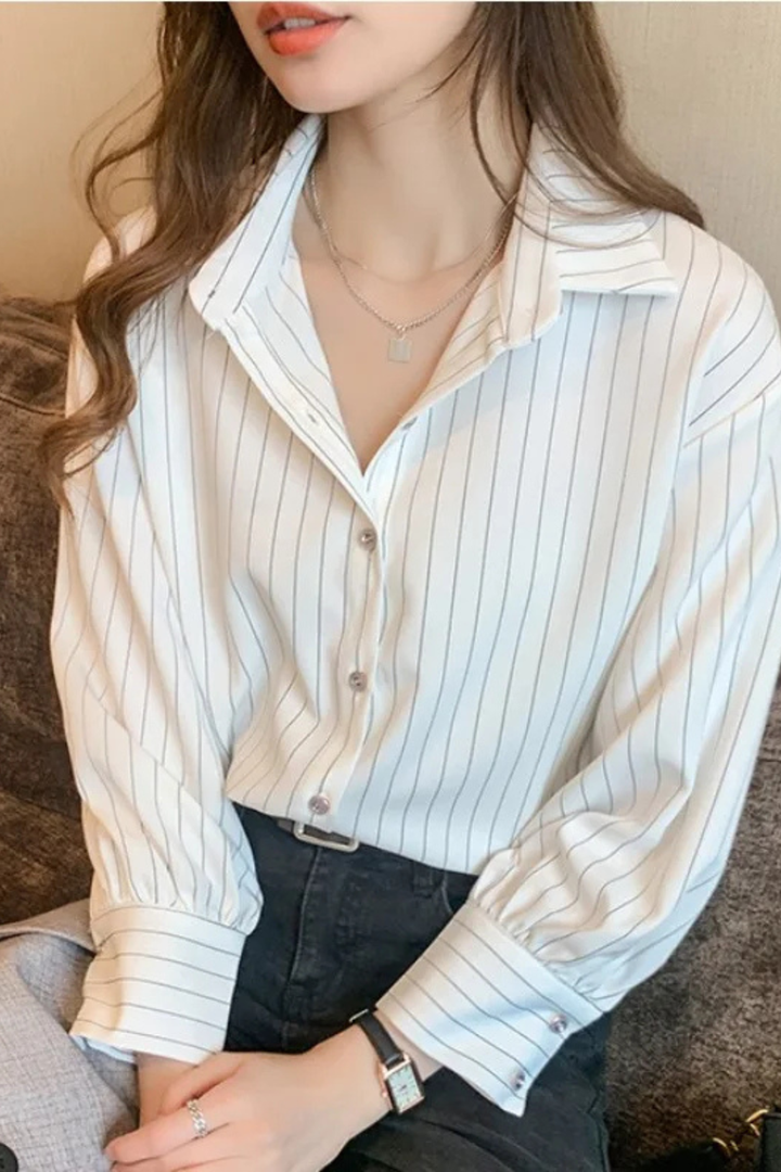 Modern women's striped button-down shirt in blue and white. Long sleeve blouse offering a chic and polished look.