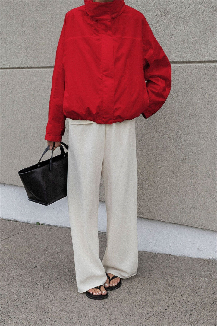 A woman layering a chic collar windbreaker jacket over a sweater for a stylish look