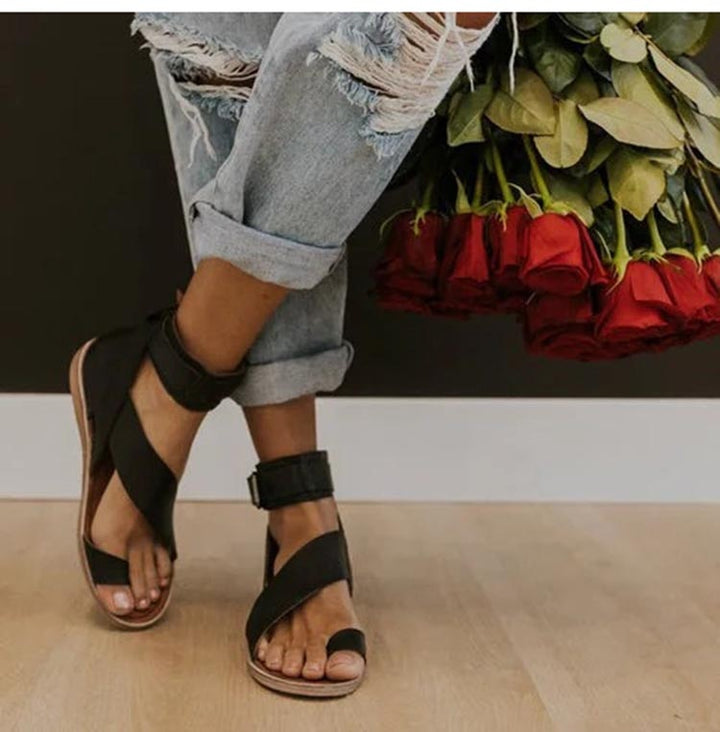 Women's chic cross strap sandals with elegant toe ring detail. Comfortable and stylish summer footwear.