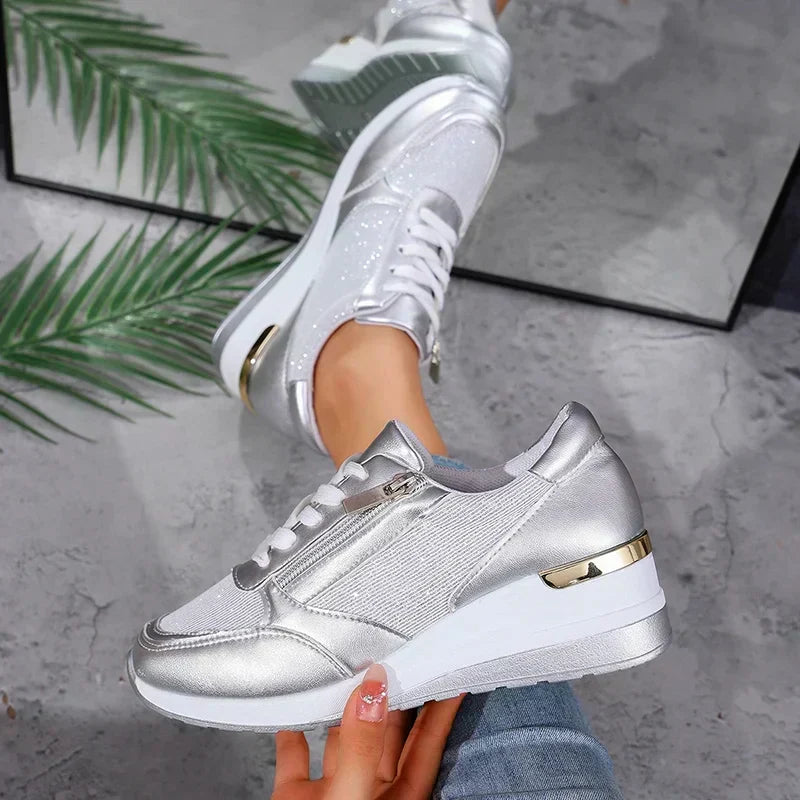 Close-up of zip detail on women's metallic orthopaedic platform trainers, adding modern style & ease.
