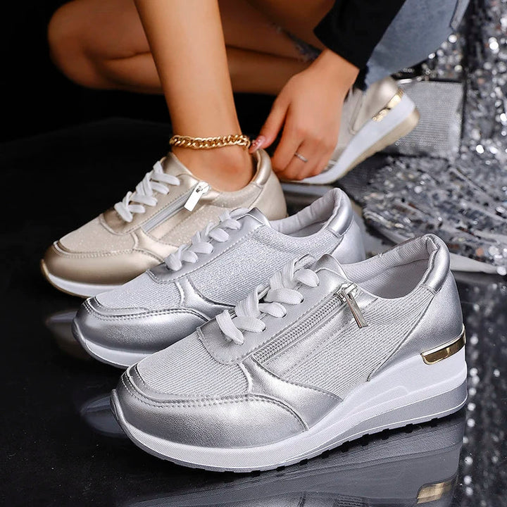 Woman wearing stylish gold orthopaedic platform trainers, comfortable fashion sneakers for a chic look.