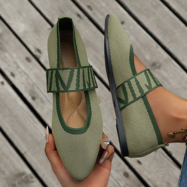 Close-up of women's chic patterned ballet flats. Detailed fabric design on elegant pointed-toe slip-on shoes.
