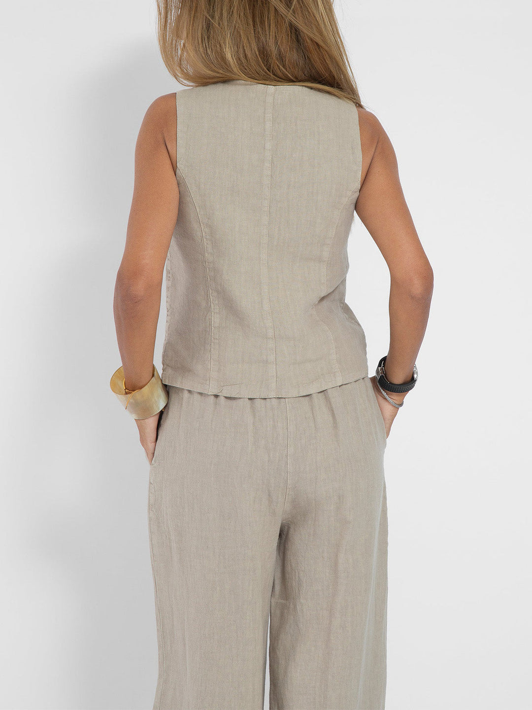 Back view of a women's elegant sleeveless V-neck wide-leg trouser set.