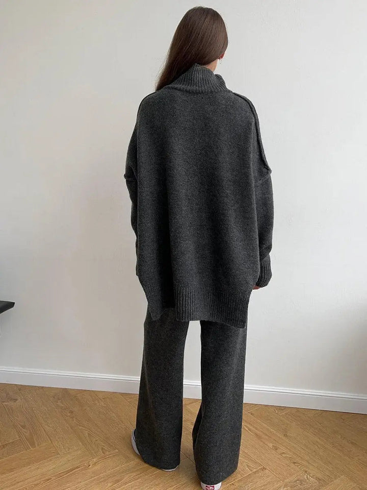 Versatile women's travel outfit: chic turtleneck set with relaxed fit sweater and wide-leg trousers.