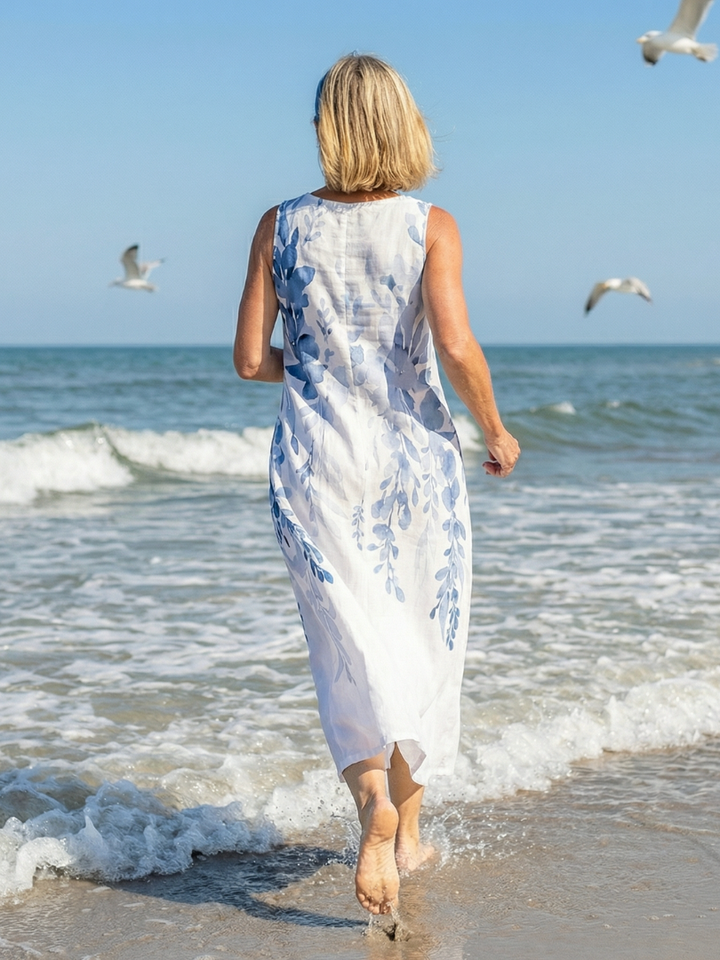 Stylish women's white sleeveless maxi dress featuring a beautiful botanical print. A comfortable, relaxed summer vacation dress.