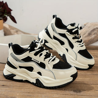 Black women's chunky platform fashion sneakers with intricate panelled details and durable sole.
