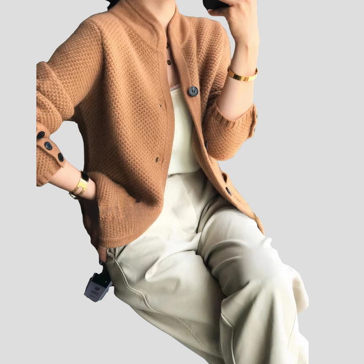 Close-up of soft women's cashmere v-neck cardigan sweater, showcasing knit texture and button detail.