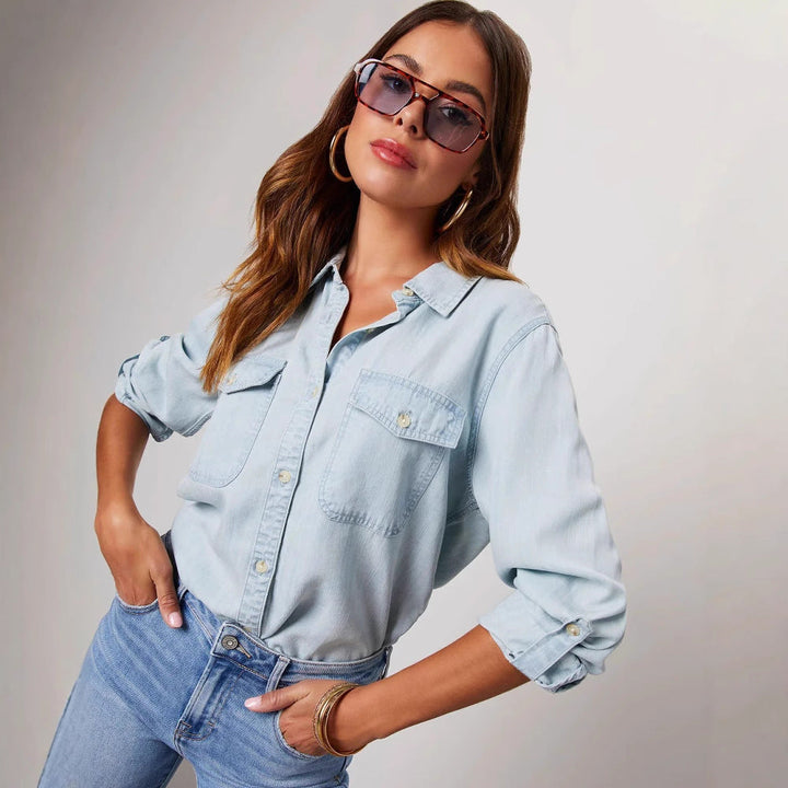 Blue denim women's shirt with button-down front & long sleeves. Features a comfortable relaxed fit.
