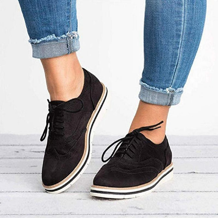 Women's fashionable lace-up brogue trainers in a close-up, showcasing their classic detailing and comfortable design.