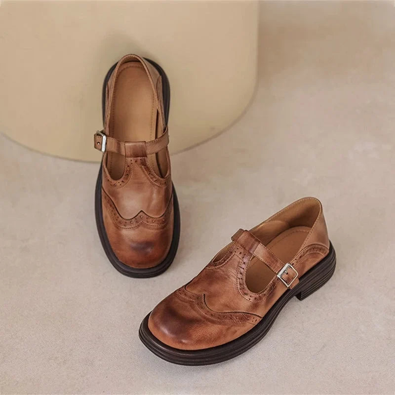 Comfortable women's Mary-Jane flat sandals, featuring a secure buckle strap and chic brogue detailing.