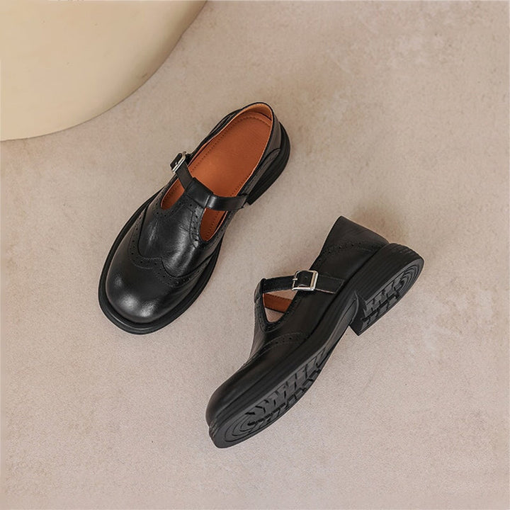 Women's Mary Jane shoes with perforated design, classic buckle strap & closed toe. Comfortable flat.