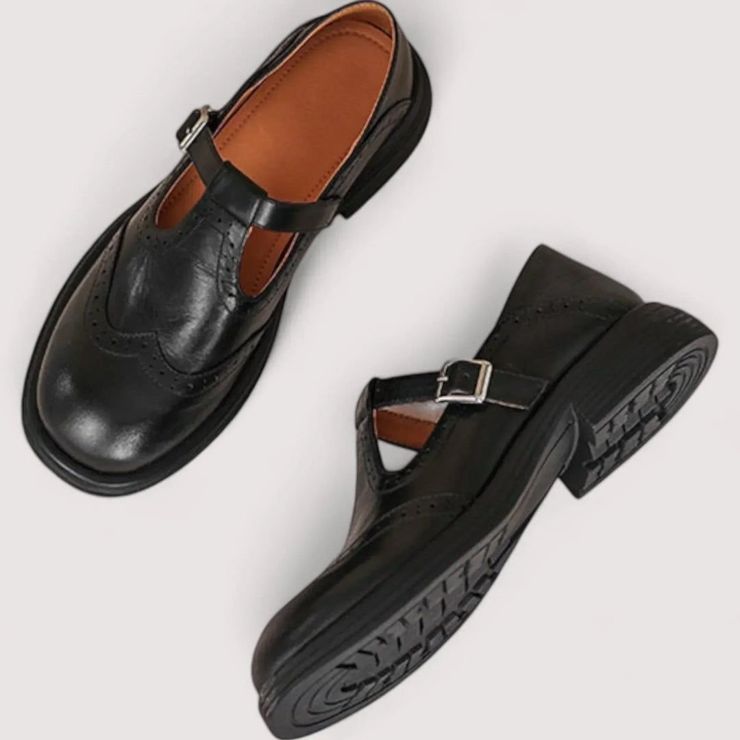 Vintage-inspired women's Mary Jane flats with sophisticated brogue detailing & secure strap for classic style.