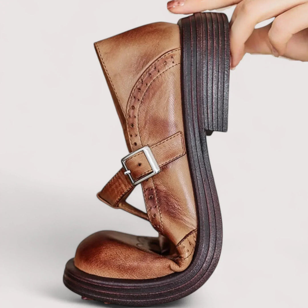 Elegant women's Mary Jane flats with intricate brogue detailing, rounded toe, and adjustable strap.