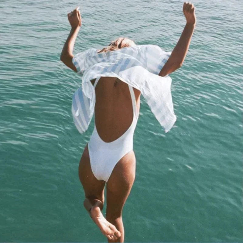 Elegant women's one-piece swimsuit with open back. Smooth fabric & solid color for timeless summer style.