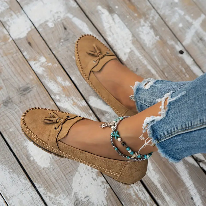 Stylish women's closed-toe slip-on loafers with classic tassel detail, perfect for dress or everyday.