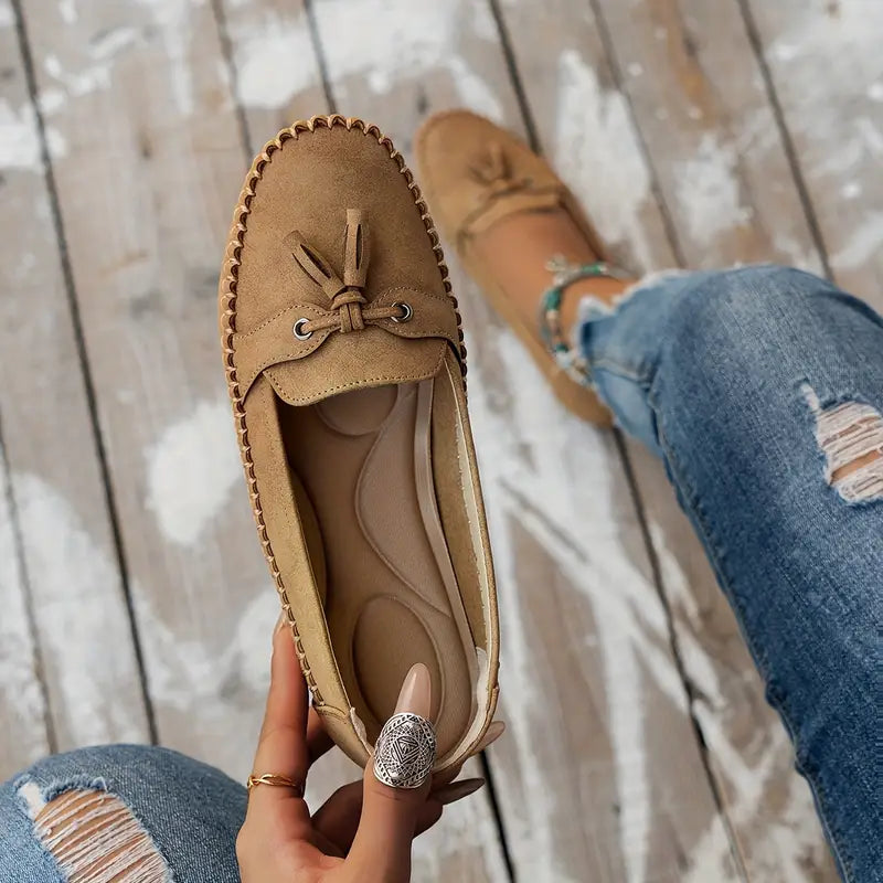 Elegant women's closed-toe slip-on loafers with classic tassel accents, ideal for professional or casual.