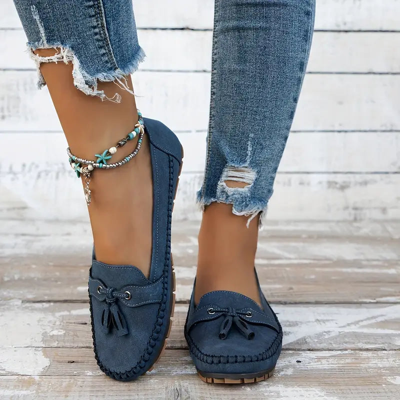 Close-up of the elegant tassel detail on women's classic closed-toe slip-on loafers. Dress shoes.