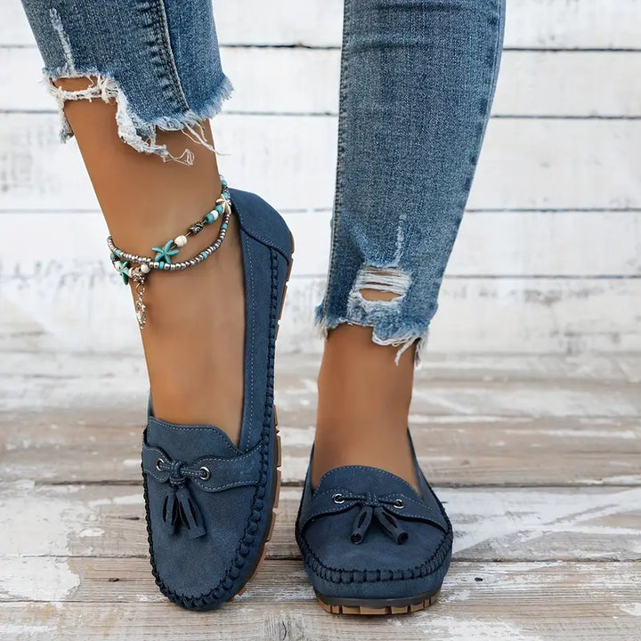 Close-up of the elegant tassel detail on women's classic closed-toe slip-on loafers. Dress shoes.