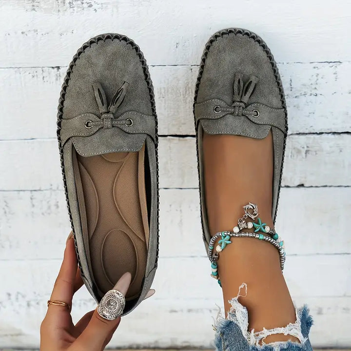 Side view of women's comfortable classic tassel loafers, a versatile closed-toe slip-on shoe.