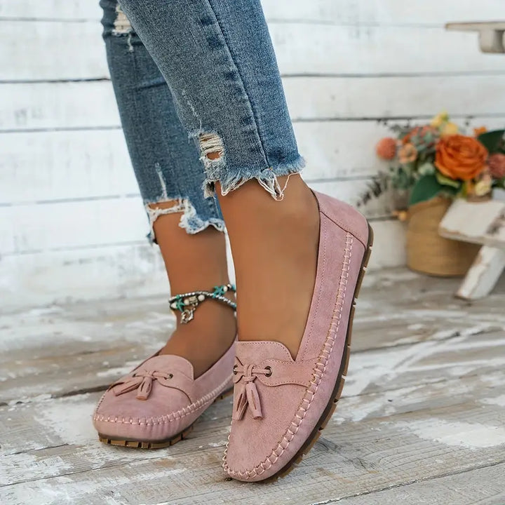 Pair of women's classic tassel loafers, closed-toe slip-ons designed for stylish comfort & everyday wear.