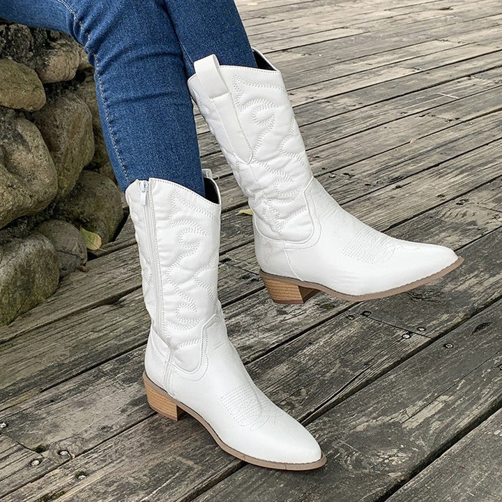 Model wearing fashionable western boots, showcasing versatile women's footwear