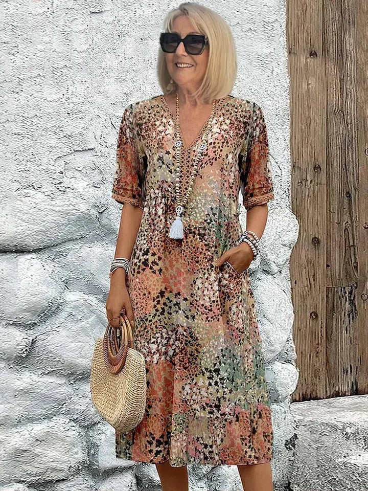 Stylish women's summer midi dress, colorful abstract print, V-neck, 3/4 sleeves. Ideal for casual elegant looks.