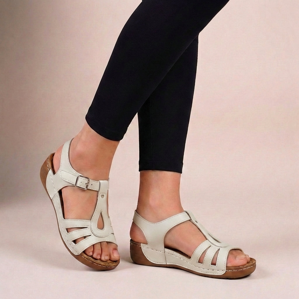 Elegant beige women's T-strap flat sandals with a secure buckle closure for ultimate comfort & summer style. Open-toe.