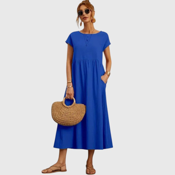 Casual women's midi dress featuring convenient pockets. Flowy fabric ensures comfortable summer style.