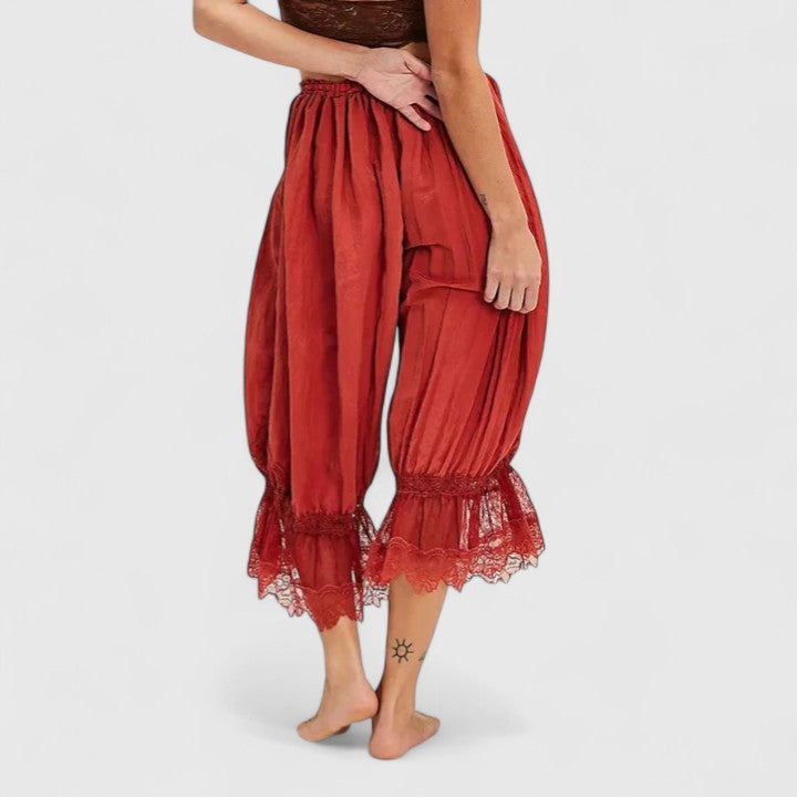 Close-up of intricate patchwork and delicate lace detail on women's loose-fit casual trousers.
