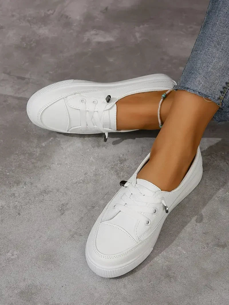 Women's comfortable white lace-up flat shoes. Round toe casual footwear for everyday versatility & comfort.