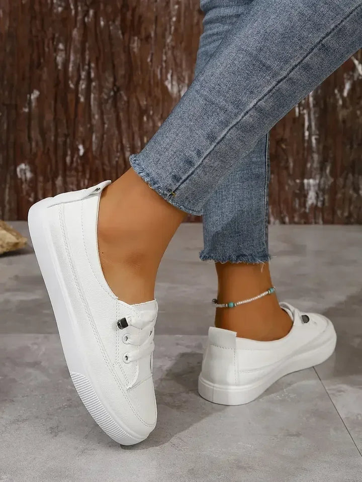 Side view of versatile white women's lace-up flat shoes. Round toe, designed for everyday comfort & style.