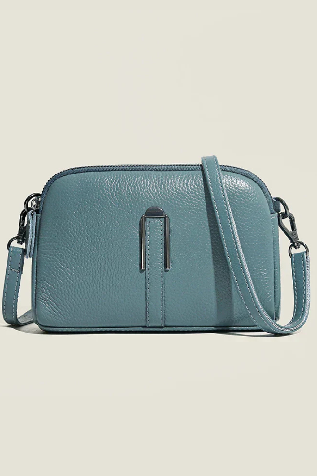 Elegant women's compact shoulder bag featuring a double zip closure and stylish textured material.