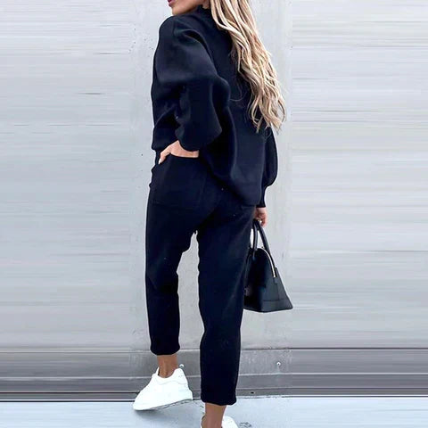 Woman relaxing in a comfy, cozy women's loungewear sweater set with drawstring pants.