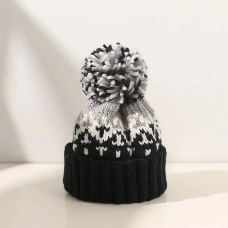 Women's cozy knit snowflake beanie with a plush pom-pom. Perfect for winter warmth & style.