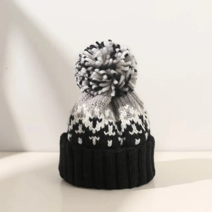 Women's cozy knit snowflake beanie with a plush pom-pom. Perfect for winter warmth & style.