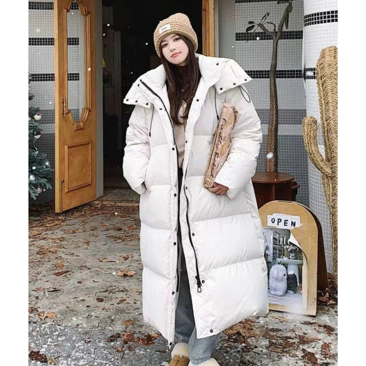 Comfortable women's long hooded puffer jacket. Ideal for staying warm and cozy during chilly winter days.