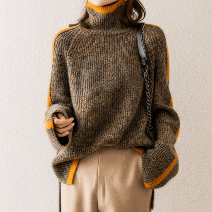 Close-up of the textured, mixed knit fabric on a women's warm turtleneck sweater. Ideal for fall & winter style.