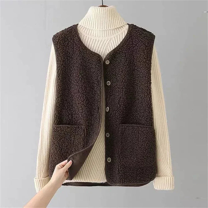 Chic women's sherpa vest featuring a button-front, V-neck, and practical patch pockets. Winter warmth.