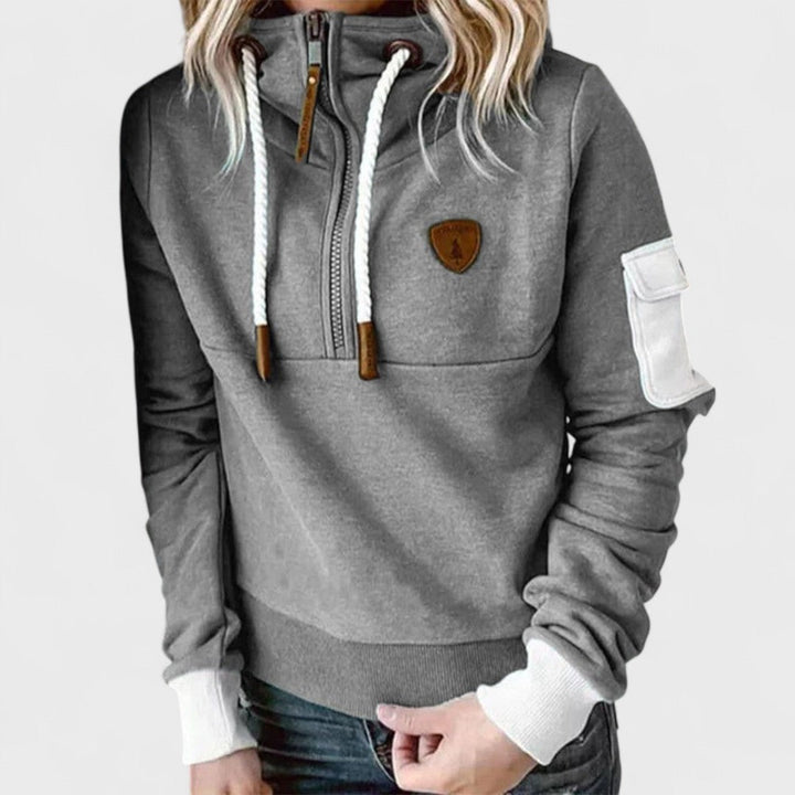Detail of modern zip neck on a women's cozy grey hoodie. Soft and comfortable loungewear jumper.